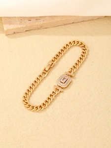 Detailed close-up of a gold Cuban chain bracelet with a central rectangular zircon stone