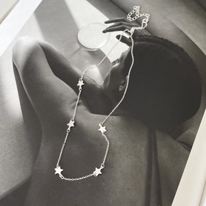 Artistic layout of a 925 sterling silver star necklace over black and white art photography