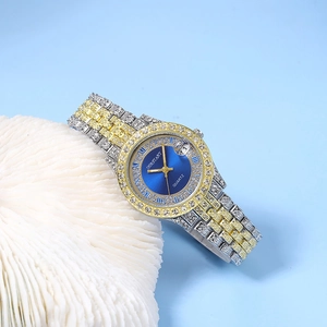 Détail d'une montre de luxe pour femme avec cadran bleu et chiffres romains sur corail blanc