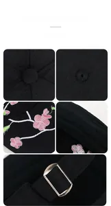 Detail of pink flower embroidery and adjustable silver metal buckle on black baseball cap