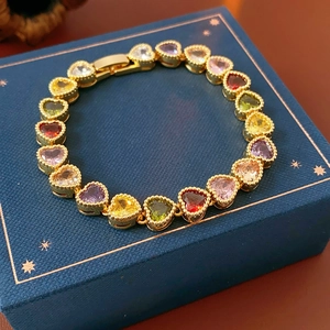Detail of colorful heart-shaped crystal bracelet with 18K gold plating on navy gift box