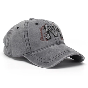 Close-up of vintage washed grey baseball cap with M embroidery and side logo
