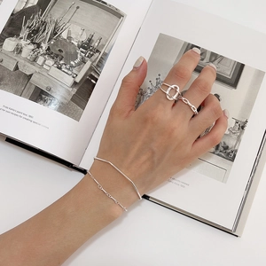Artistic display of S925 sterling silver minimalist bracelet and ring set on hand