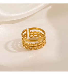 Detailed view of a gold triple-layered open ring with north star on white silk cloth
