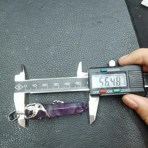 Digital caliper measuring the 56.48mm length of a purple crystal pillar pendant detail