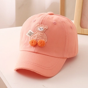 Detail of coral pink kids baseball cap with cute bear patch and COOL DUDE label