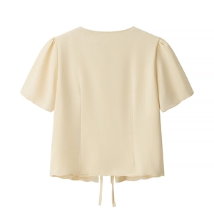 Detail view of beige puff sleeve top back with adjustable drawstring hemline design