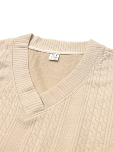 Detailed macro view of beige V-neck knitted sweater texture and soft fabric material