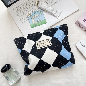 Detailed top view of a large-capacity argyle makeup bag with a Pleasant Time label on a desk