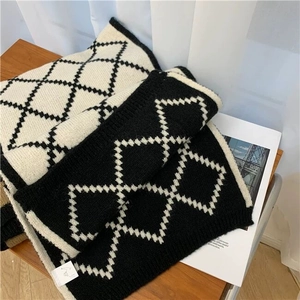 Detail of checkered knit scarf texture showing black and white diamond patterns