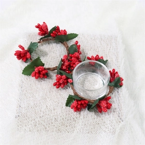 Detail of pine needle napkin ring with green leaves and red berries on white plush fabric