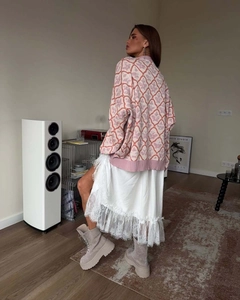 Detail of pink plaid knit cardigan with white lace maxi skirt and platform boots