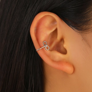 Détail d'un ear cuff infini argenté montrant le design géométrique sur l'oreille du mannequin