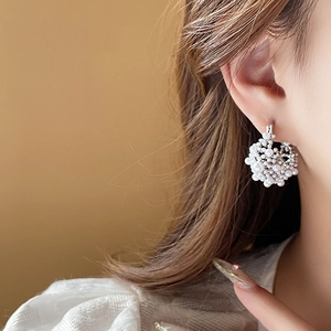 Close-up of model wearing French vintage pearl cluster hoop earrings with gold plating