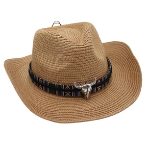 Detail of western straw cowboy hat with ethnic braided band and silver bull skull ornament