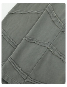 Detailaufnahme der dekonstruierten Kanten an olivgrüner Baumwollhose im Vintage-Stil