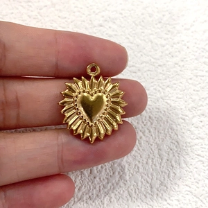 Macro shot of gold-plated stainless steel heart pendant with sunburst design details