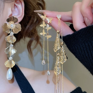 Detailed close-up of 18K gold-plated floral earrings with pearls and butterfly tassels