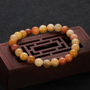 Natural agate and chalcedony beaded bracelet featuring warm tones on a dark wood display box