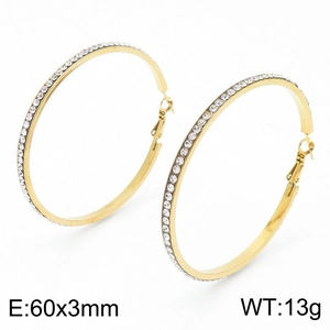 Détail des boucles d'oreilles créoles dorées de 60mm serties de strass étincelants
