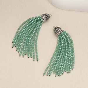 Detail of green beaded tassel earrings with sparkling rhinestone caps and faceted beads