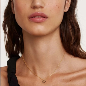 Elegant gold S925 silver necklace with black heart pendant worn on neck