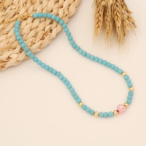 Detail of turquoise beaded necklace with owl pendant and gold lobster clasp