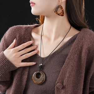 Elegant model wearing brown leopard resin necklace and triangle stud earrings set
