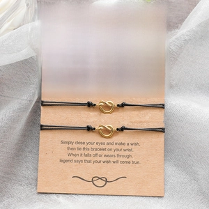 Close-up of three black cord knot bracelets on a kraft display card for friendship gift