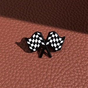 Close-up of racing checkered flag enamel pin with butterfly clasp on leather texture