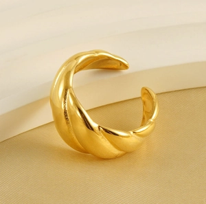 Macro shot of gold-plated croissant dome ring with a polished twisted texture