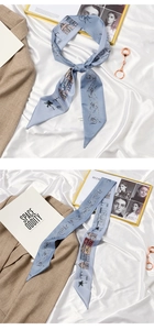 Detail of blue French bow hair scarf with architectural print styled on a white fabric
