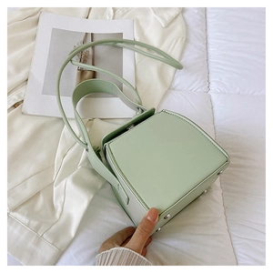 Detailed view of mint green PU leather box bag featuring protective metal bottom studs