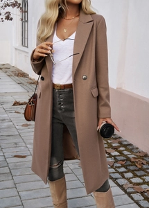 Detailed view of the double-breasted lapel and flap pockets on this brown long coat