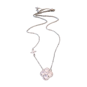 Collier élégant avec pendentif trèfle à quatre feuilles et zircons sur fond blanc