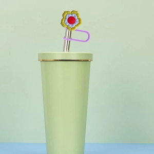 Green Stanley tumbler with a golden rim featuring a cute sunflower straw cover topper