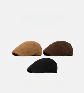 Close-up of three classic British style flat caps in camel, dark brown, and black colors