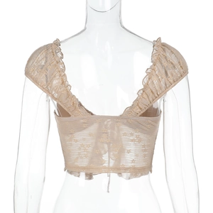 Detail view of champagne floral lace cropped top with elegant ruffled edges on the back