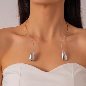 Détail d'un tour de cou en métal poli argenté avec pendentifs gouttes minimalistes