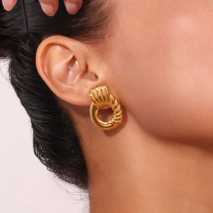 Close-up of 18K gold-plated twisted hoop earrings with textured spiral design on ear