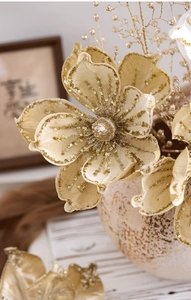Close-up of champagne gold artificial flower with sequins and glittered stamen details