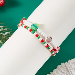 Close-up of Christmas beaded bracelet with festive tree and reindeer charms on white stand