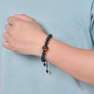 Men's Tiger Eye and lava stone beaded bracelet worn on wrist with adjustable braided cord