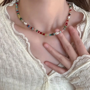 Colorful beaded necklace with freshwater pearls and gold spacers on elegant model neck