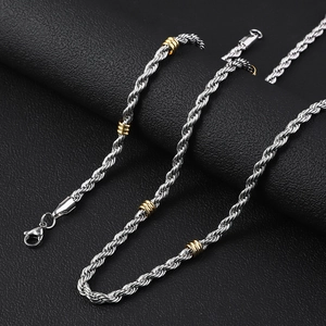 Detalle de cadena de cuerda plateada con cuentas doradas sobre cuero negro