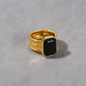 Primer plano detallado de anillo dorado vintage con banda texturizada y ónix negro incrustado