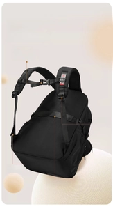 Detail of padded shoulder straps, chest buckle and luggage strap on black backpack