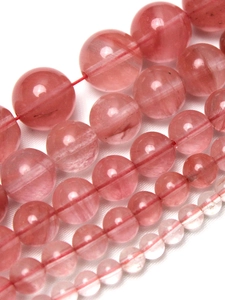 Makroansicht von wassermelonenroten Chalzedon-Rundperlen in verschiedenen Größen für Schmuck