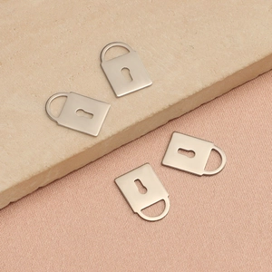 Gros plan de quatre pendentifs cadenas en acier inoxydable poli argenté avec détails