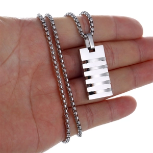 Hand holding silver rectangular bar pendant necklace with striped texture and round link chain